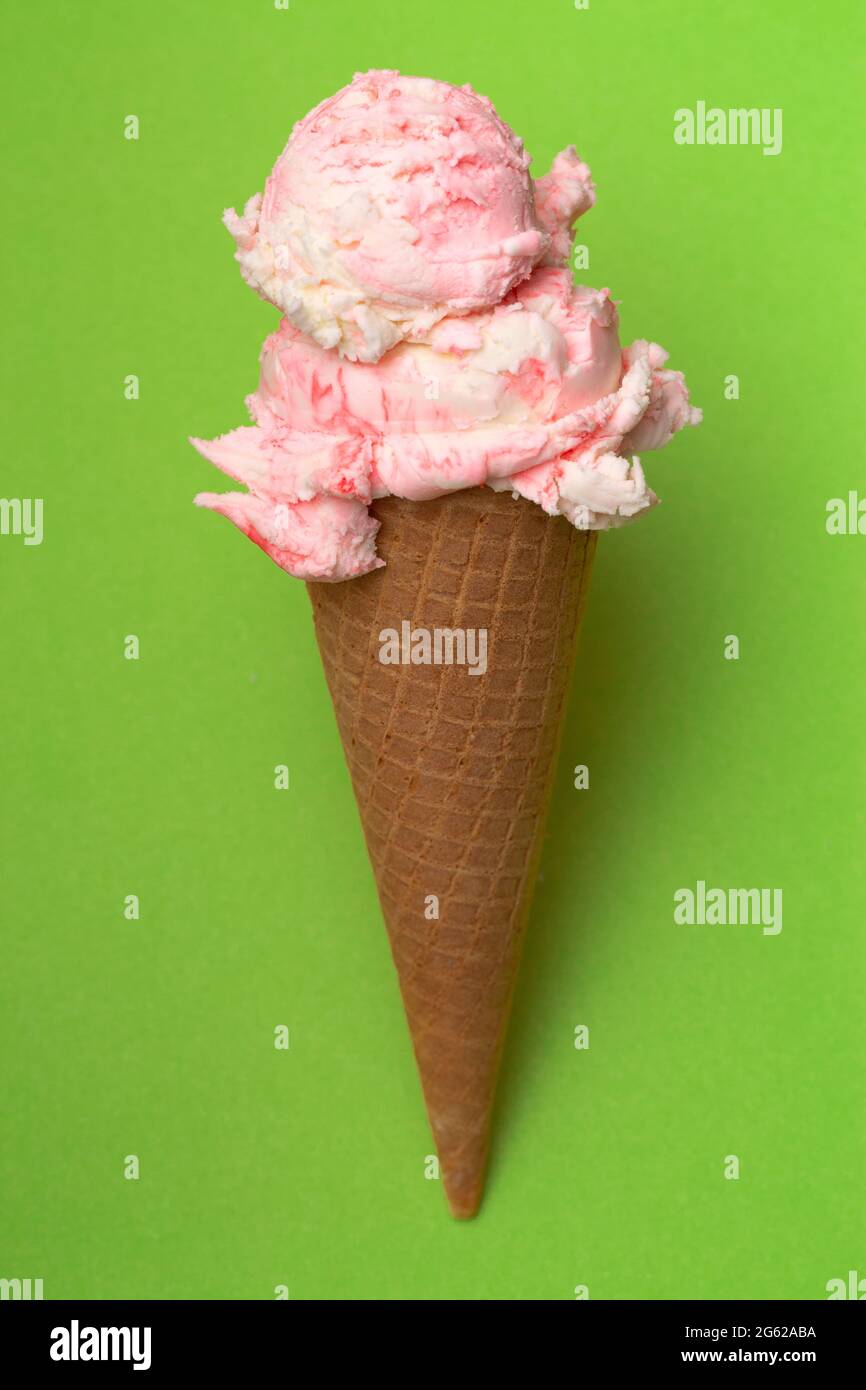 Double Scoop of Strawberry Ice Cream in a Waffle Cone on a Green ...