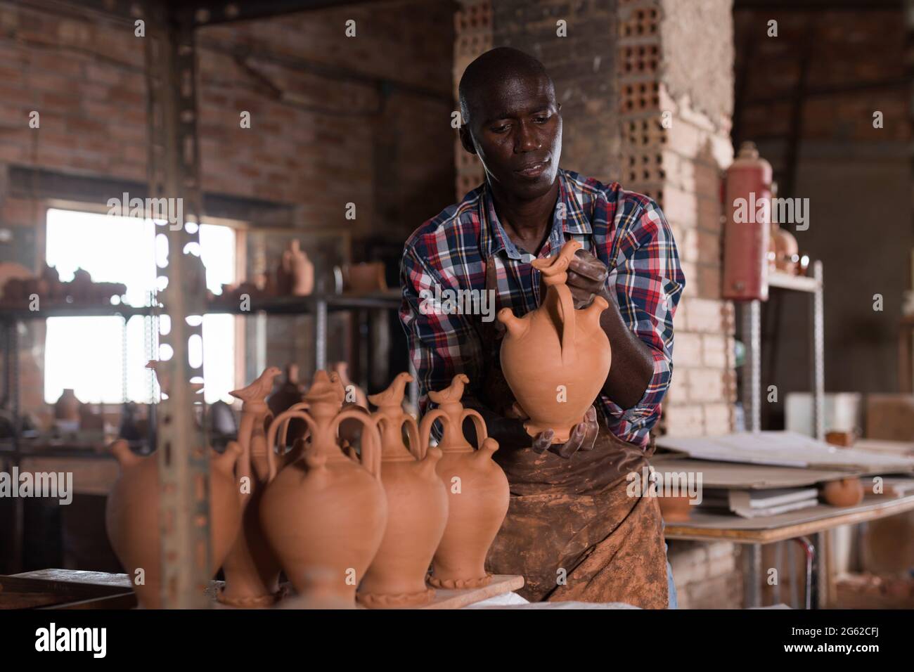 Craftsman examining handmade earthenware Stock Photo Alamy