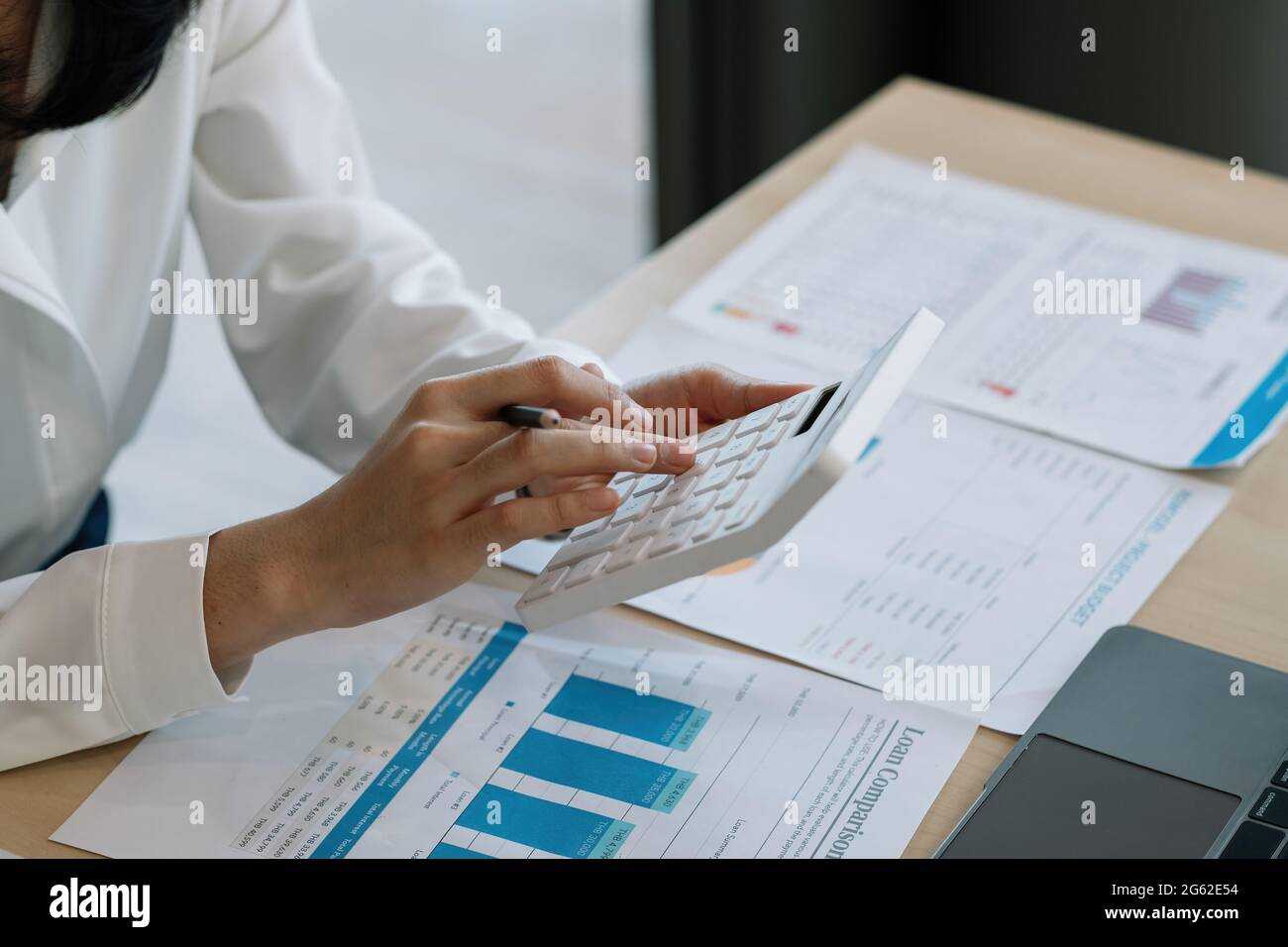 Close up busy woman using calculator, renter checking bills, planning budget, sitting at desk with financial documents and receipts, accounting Stock Photo