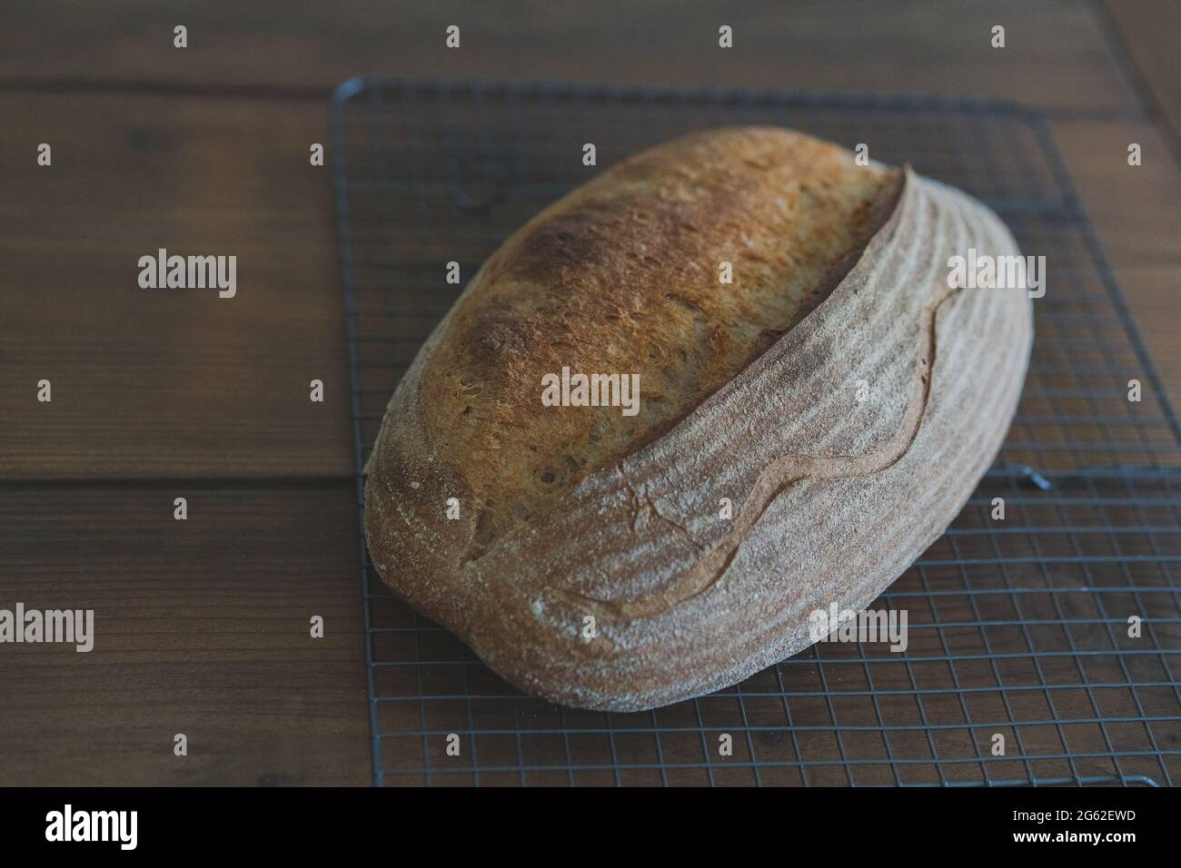Homemade sourdough bread artisan freshly baked on a cooling rock wood table background Side view Stock Photo