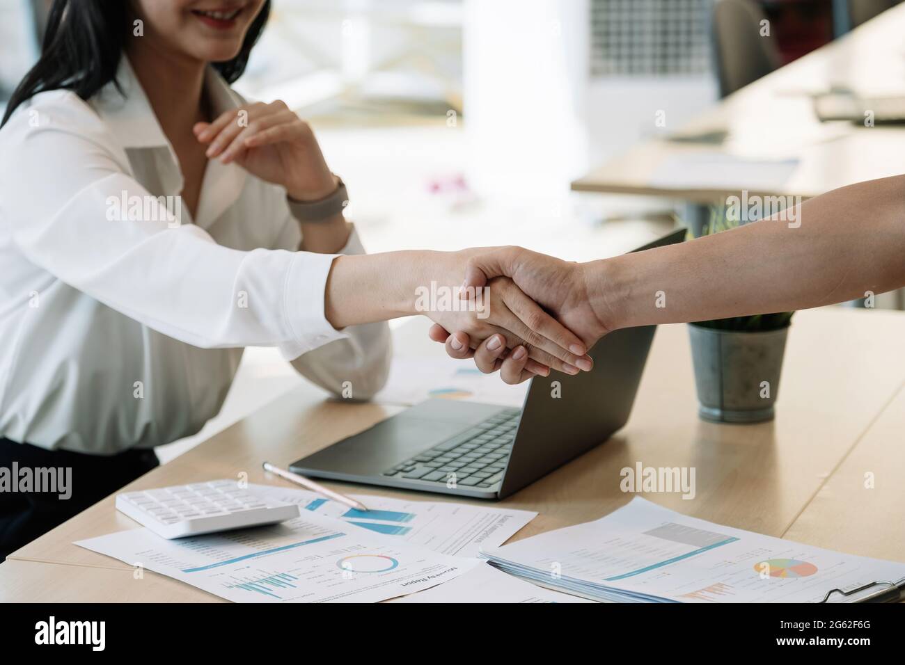 Financial accountants and marketers shaking hand to congratulate the real estate performance, business etiquette, congratulation, merger and Stock Photo