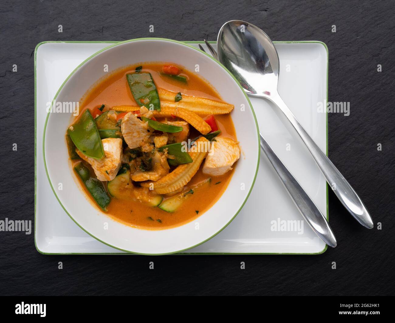 Spicy Red Thai Curry with Chicken and Vegetables in a Bowl, Top View Stock Photo