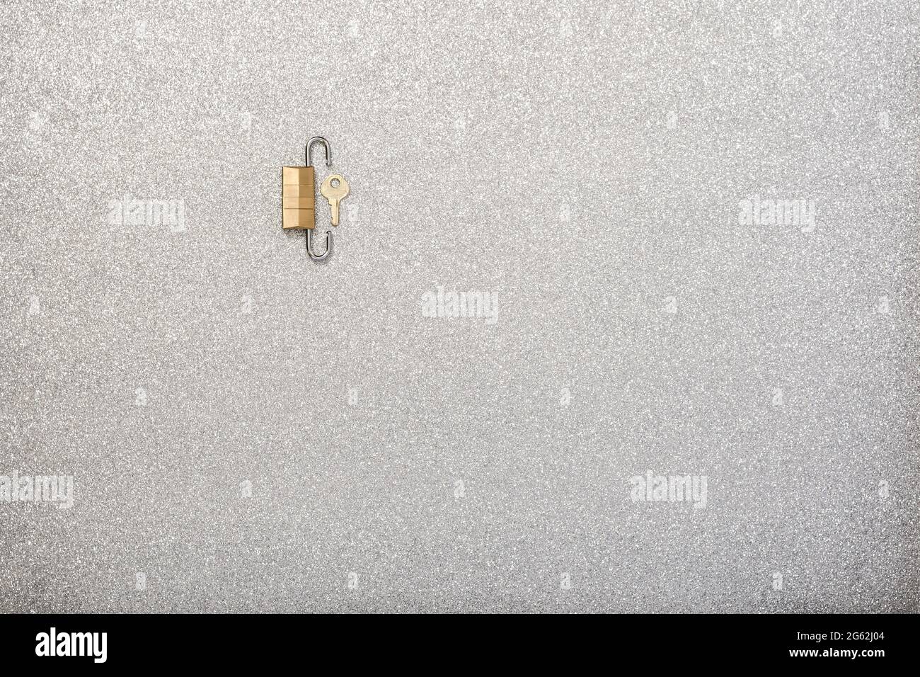Silver background and two golden padlocks that are intended to show a concept.The photo has copy space to put text and is shot from an overhead point Stock Photo