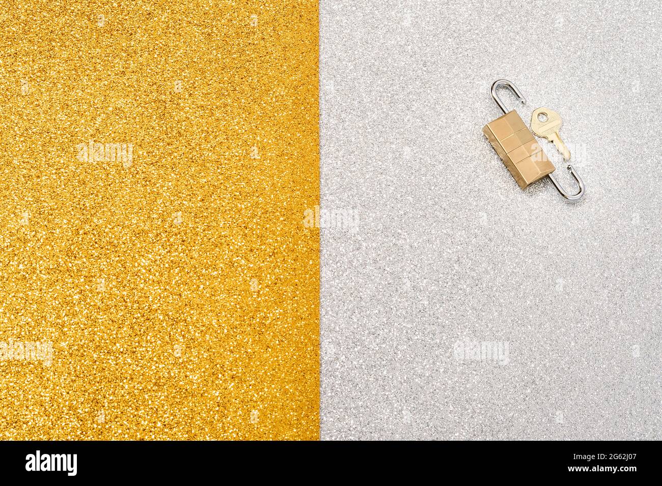Photo of two padlocks and a small key on a silver and gold background that pretends to show a message.The photo has copy space for text or whatever yo Stock Photo