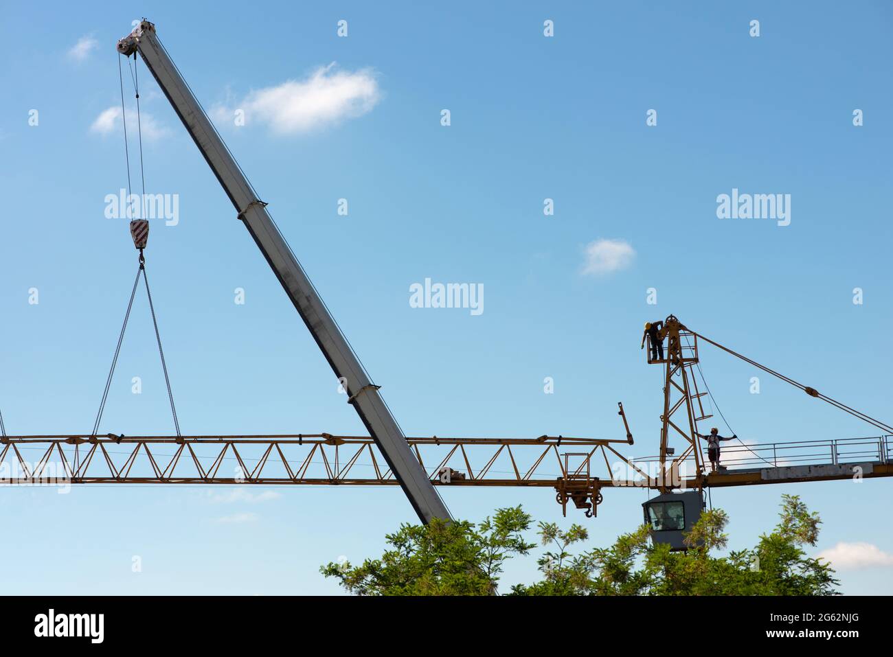 Tower crane assembly. Builders working on construction crane Stock