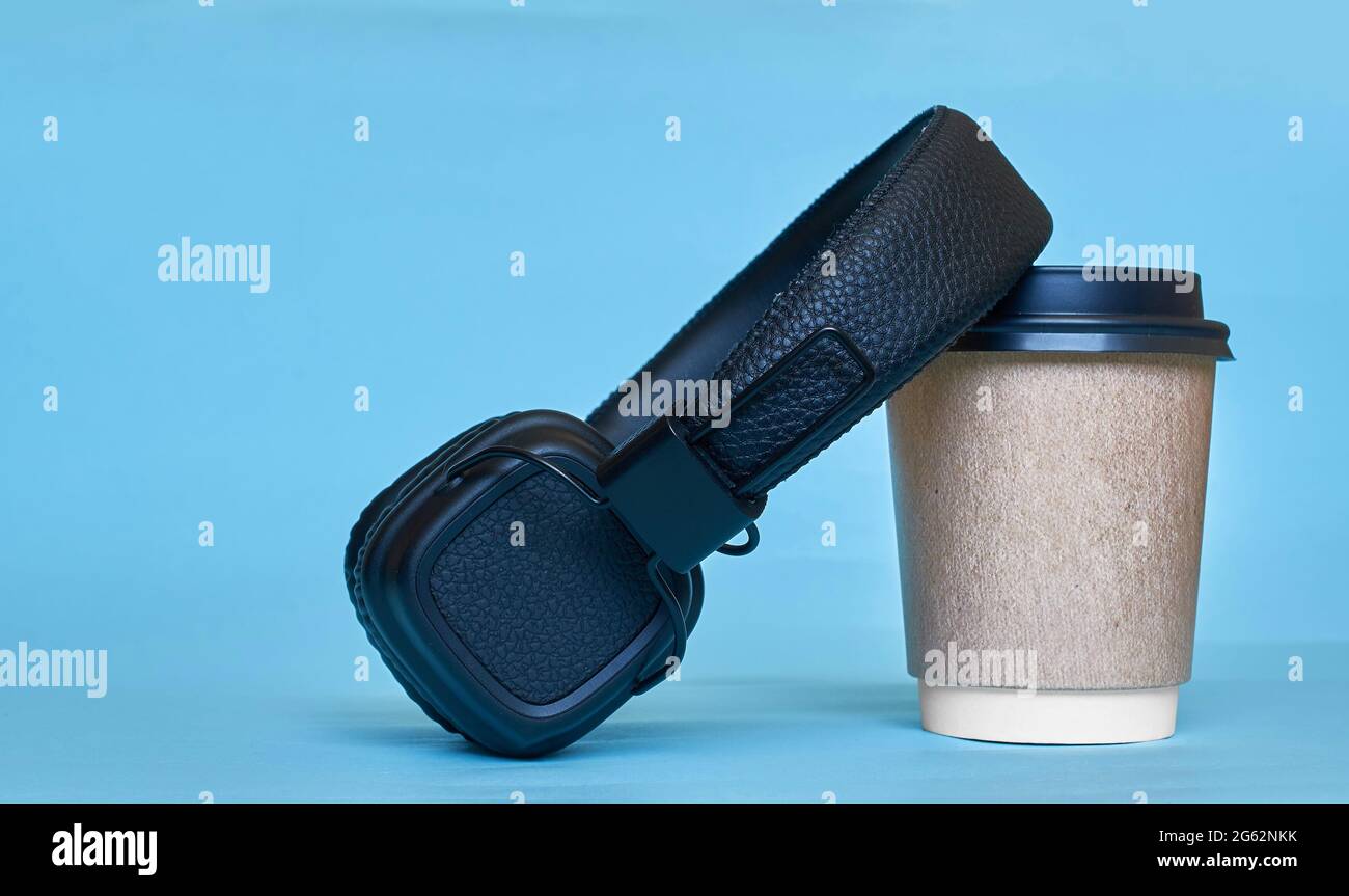 A paper cup for coffee and wireless headphones Stock Photo - Alamy