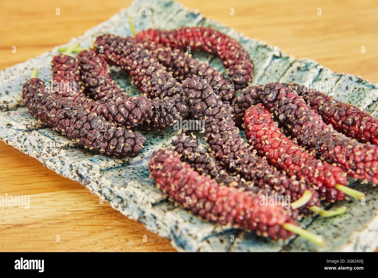 Afghan mulberry black and red lying on plate, close-up Stock Photo