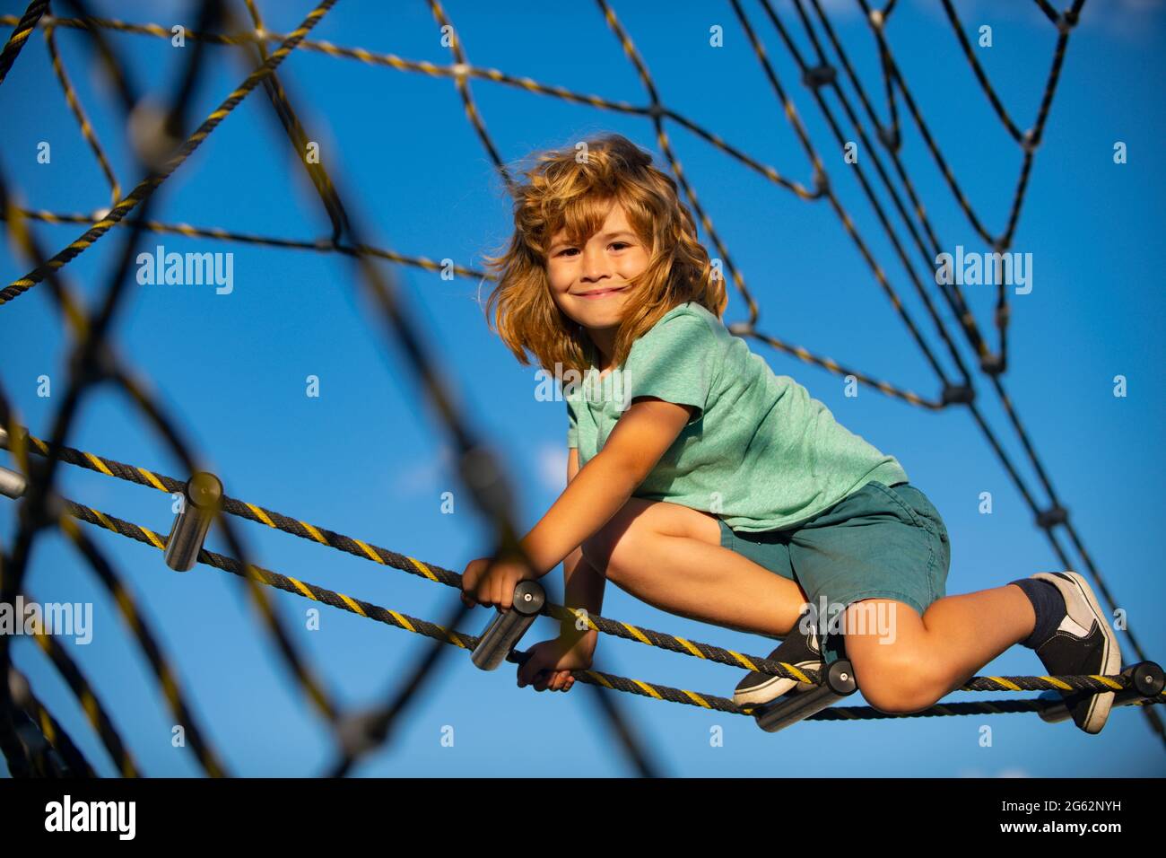 Happy child boy playing on the rope outdoor playground Stock Photo - Alamy