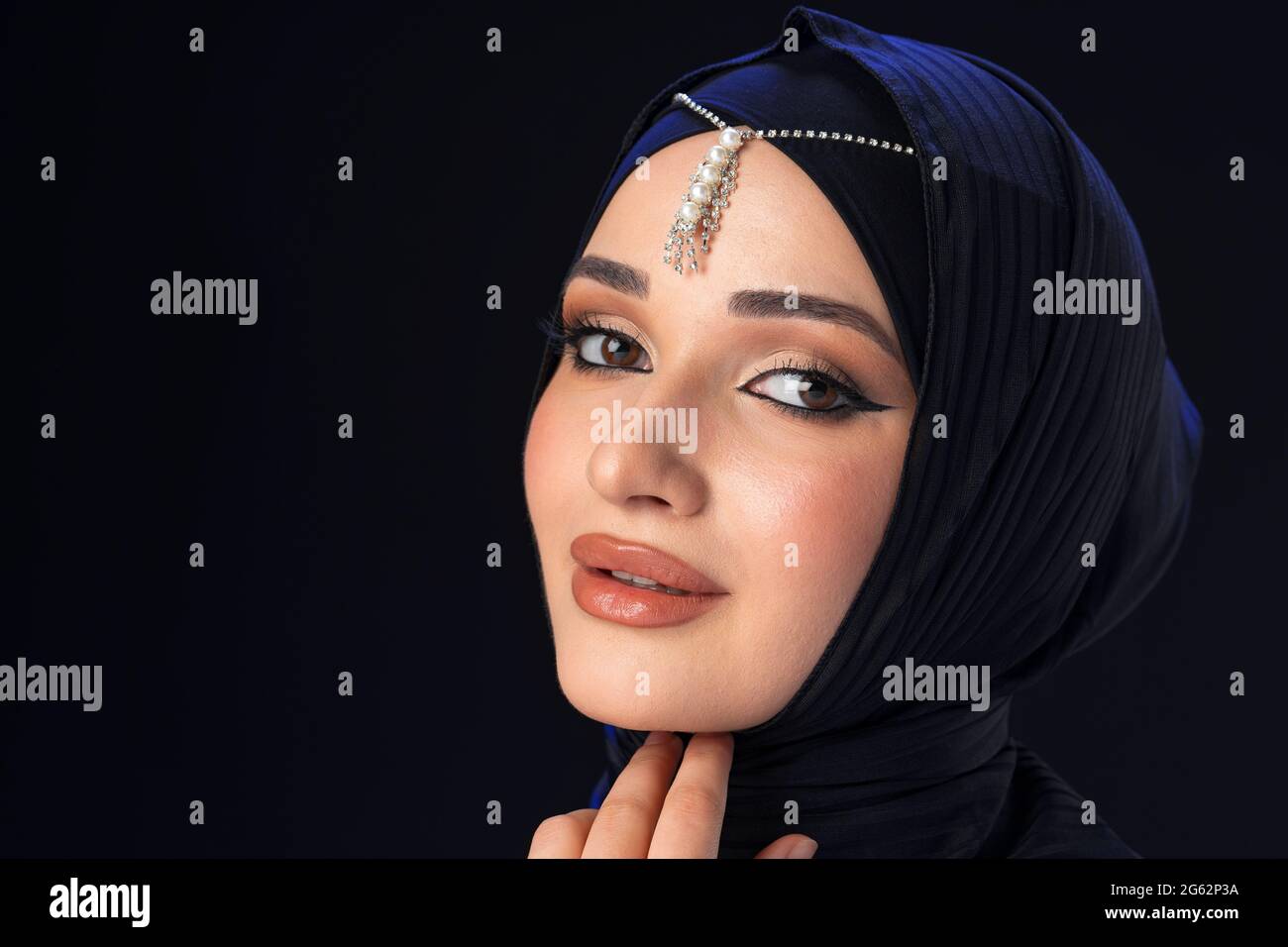 Portrait of a young muslim woman in hijab on black background Stock ...