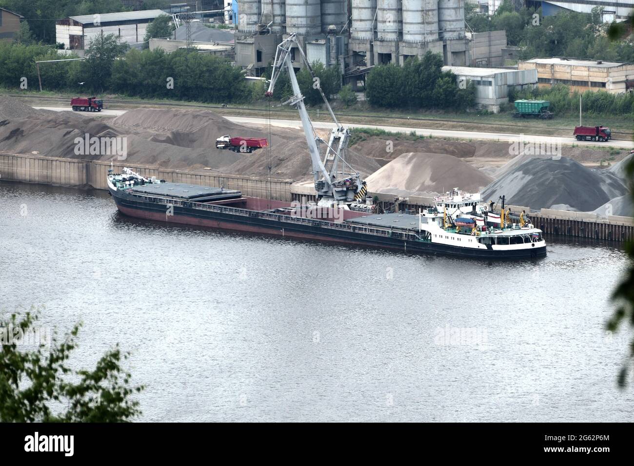 Barge on the river Unloading river sand from a barge Navigable river, river port Stock Photo