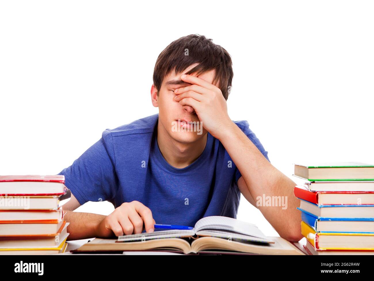 Tired Teenager Rub the Eyes on the School Desk Isolated on the White Background Stock Photo