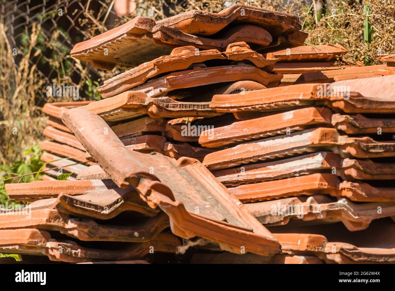 A pile of old tiles, removed from the roof of the house. Stock Photo