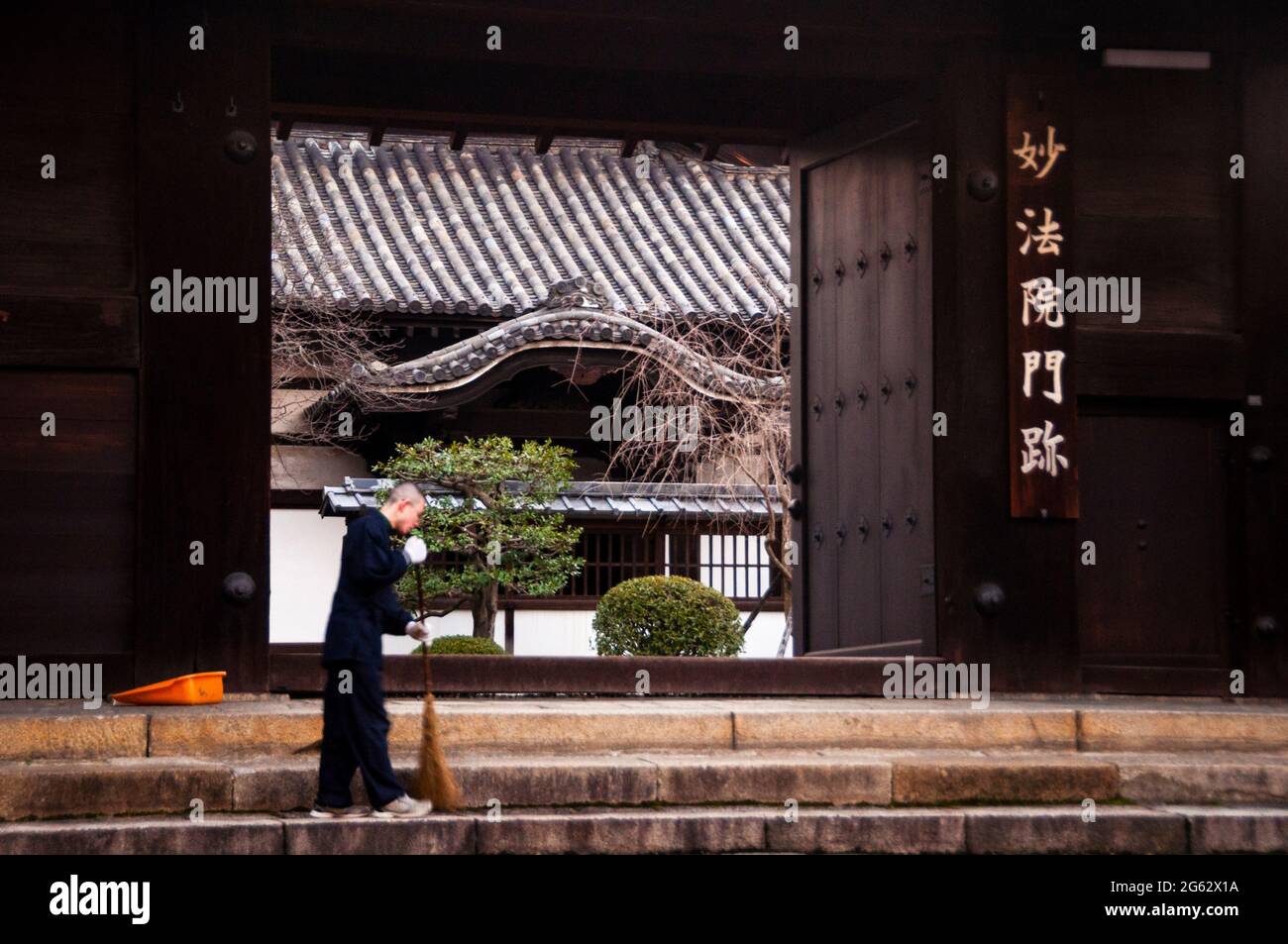 Morning chores outside the gate of a Buddhist temple in Kyoto, Japan. Stock Photo