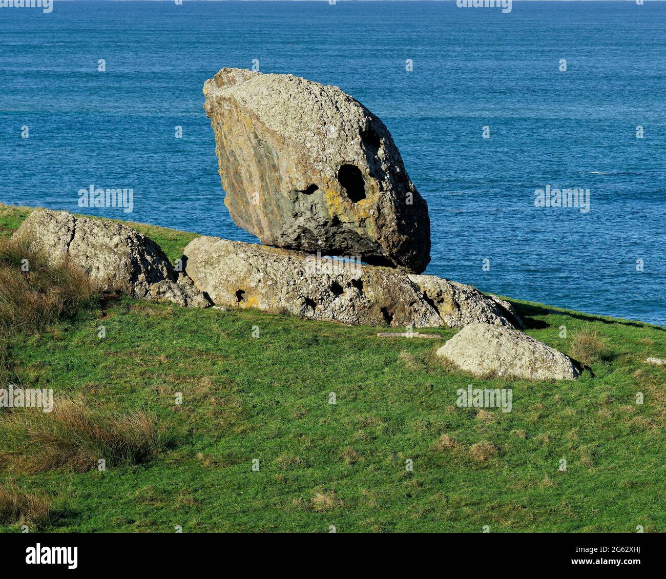 Balancing Rock is a huge argillite boulder on another flatter boulder along the Riverton coast. Southland, south island, New Zealand. Stock Photo