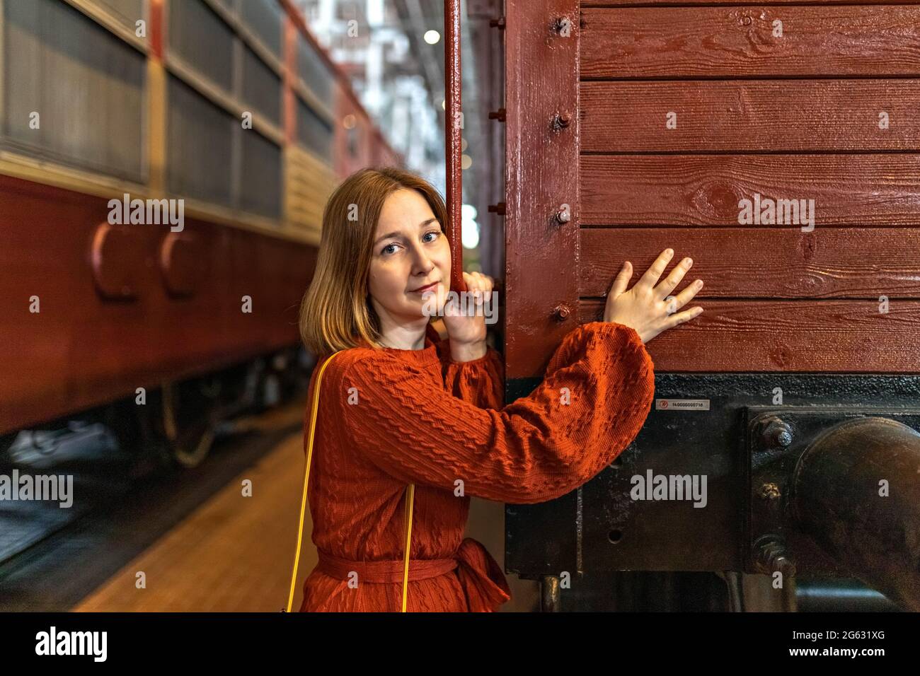 A young woman at the railway station between the cars. Stock Photo