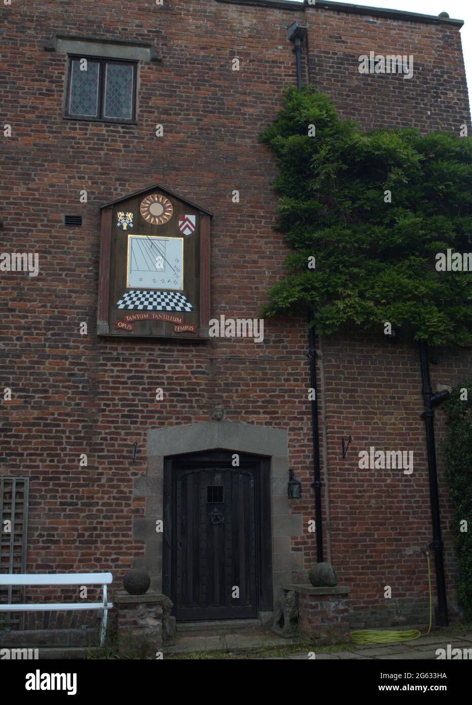 Side entrance to Gawsworth Hall featuring the Sundial hanging above the door Stock Photo