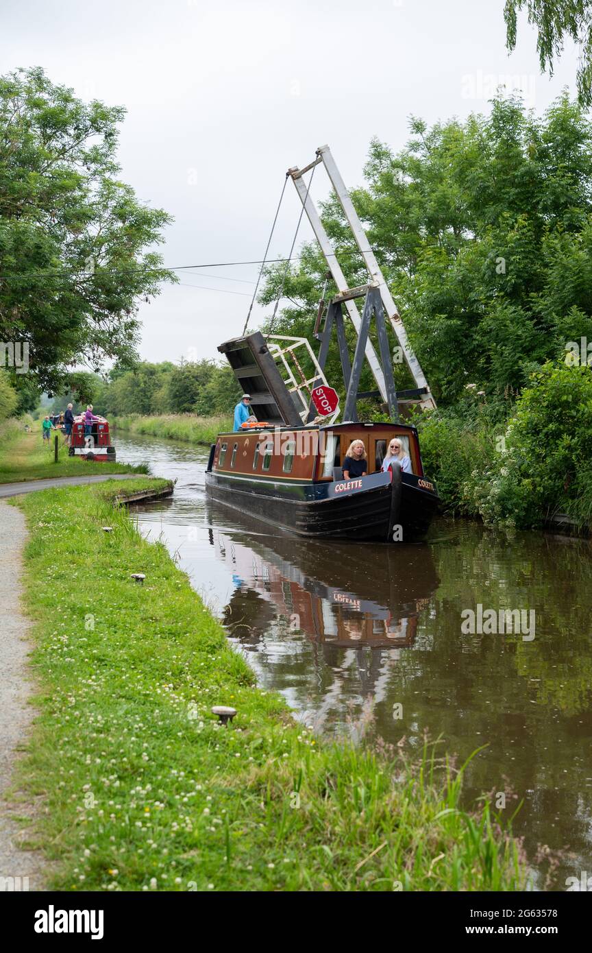 Narrowboat, carrying holidaymakers, passing under Morris Lift Bridge, No 45, on the Llangollen canal in Shropshire Stock Photo