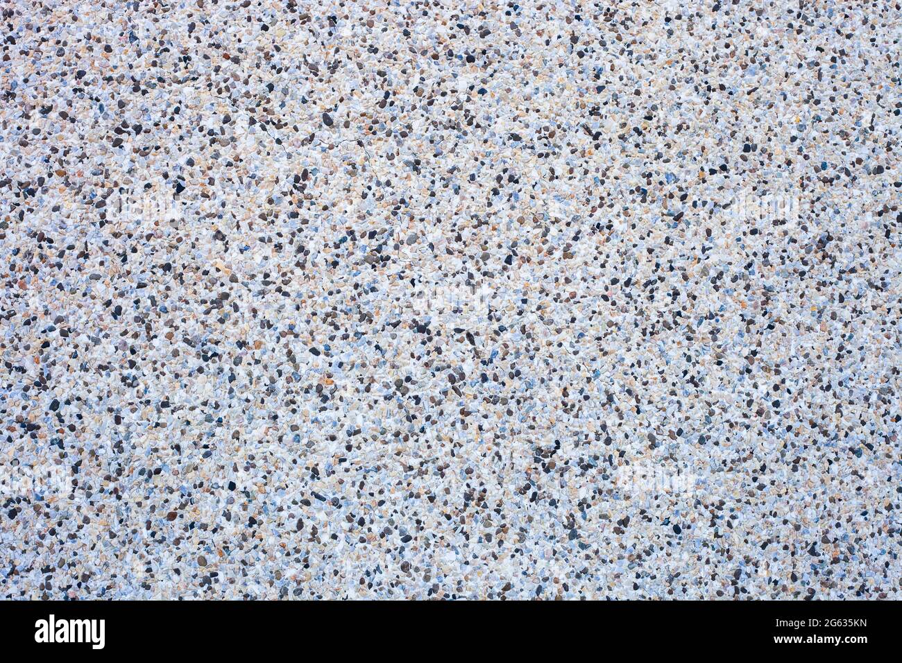 Abstract background decorative mosaic plaster. Stucco backdrop with rocks crumbs. Pebble plaster finishing - surface coating made of small stones Stock Photo