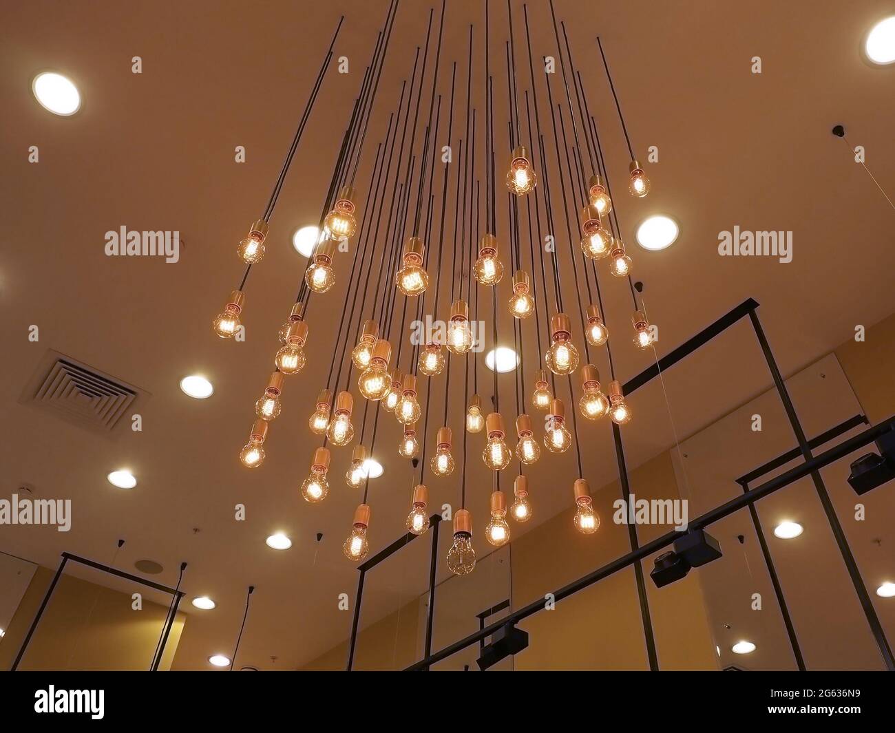 Many glowing bulbs hang from the ceiling. Decorative lighting Stock Photo