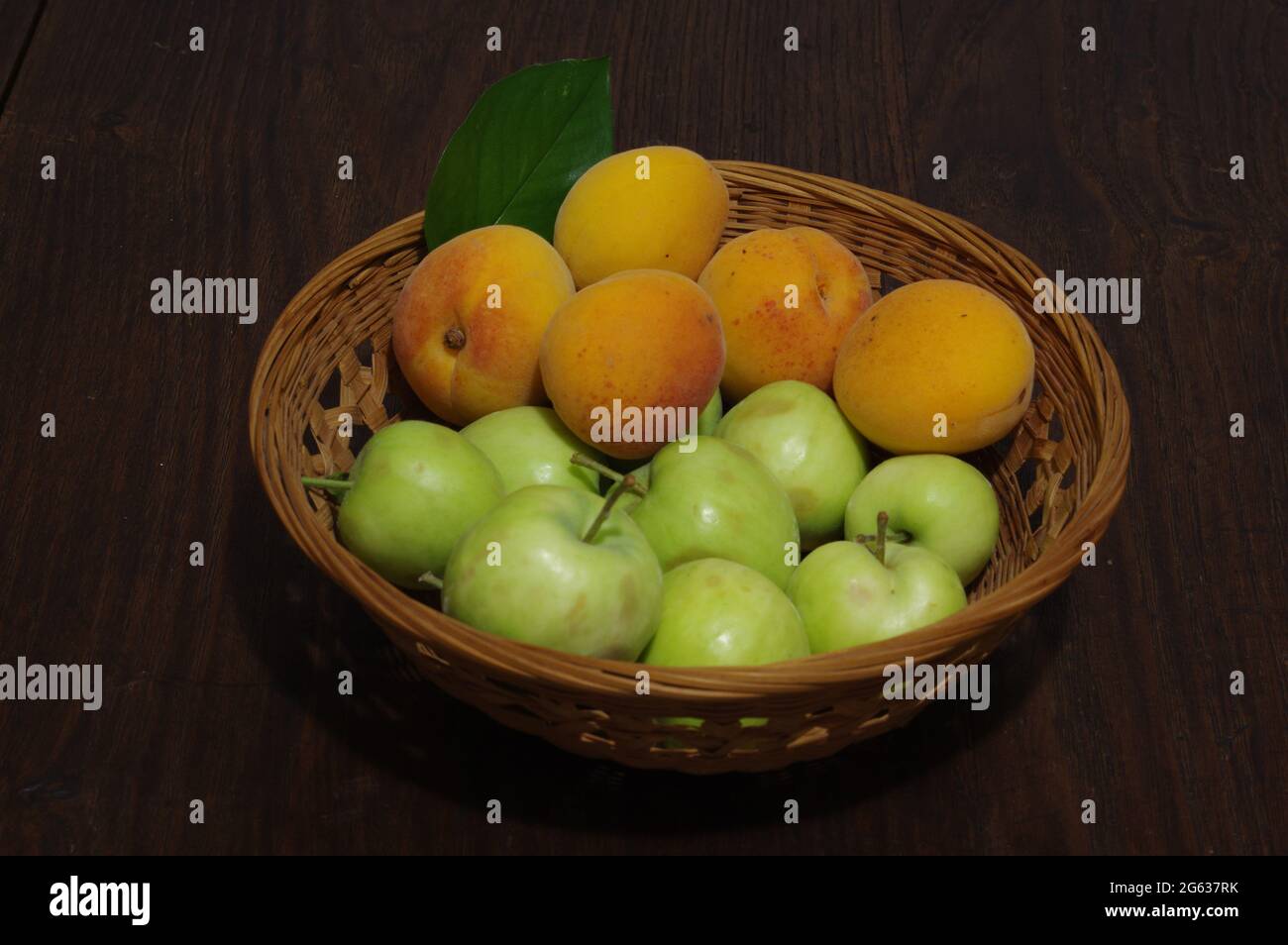 Apricots and apples on wooden table Stock Photo