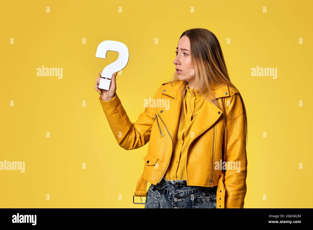 beautiful woman with question mark on studio background Stock Photo - Alamy