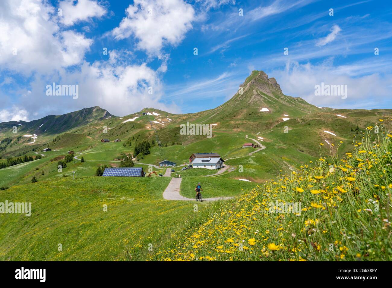 happy senior woman riding her electric mountain below Mittagsspitze summit near the village of Damuels in the Bregenz Forest mountain of Vorarlberg, A Stock Photo