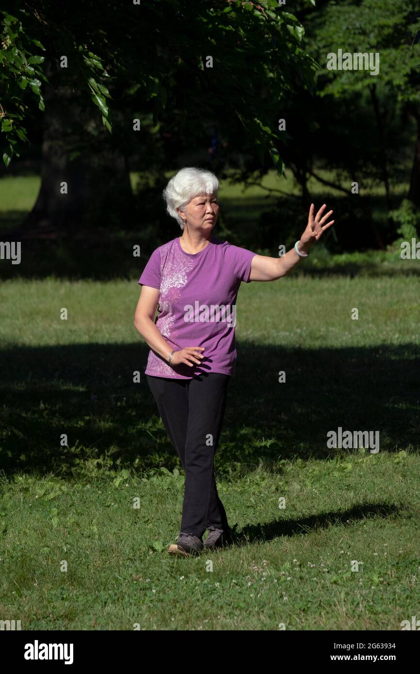 BAGUA. Asian American Buddhists circumambulate a tree as a sign of veneration. In a park in Queens, New York Stock Photo