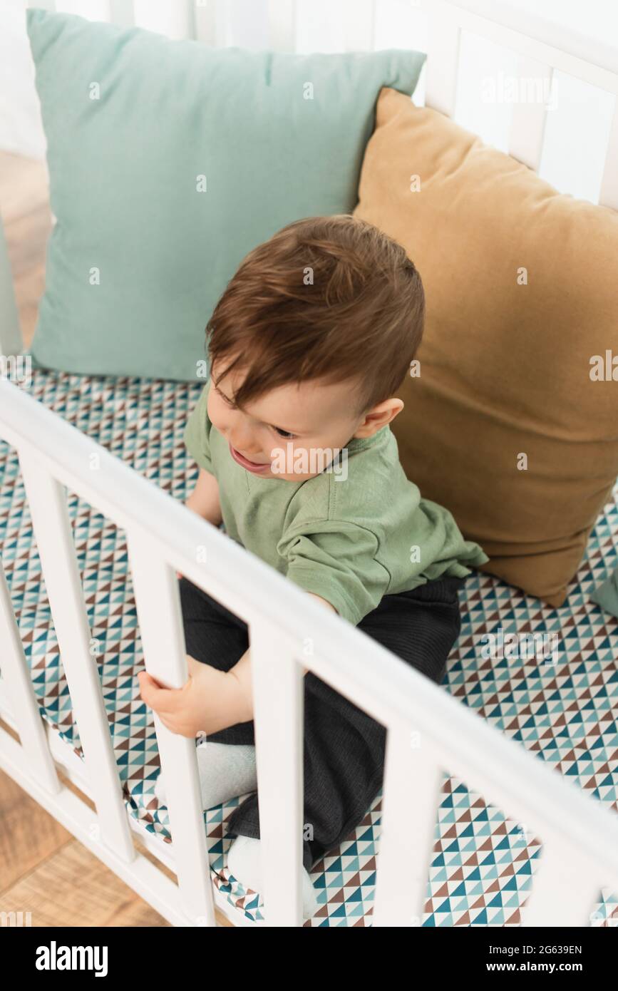 Overhead view of toddler boy sitting in baby bed Stock Photo Alamy