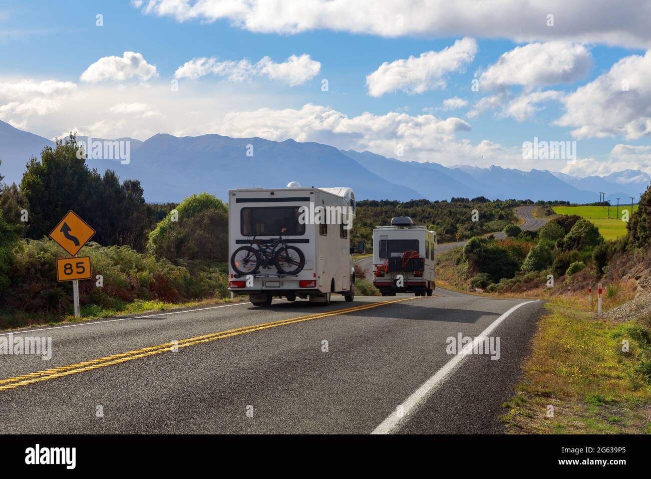 Recreational vehicles driving into Fiordland, New Zealand, through a scenic landscape Stock Photo