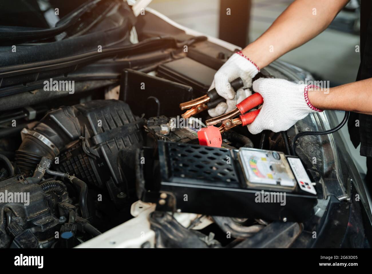 Close up hand of Car repairman with multimeter device for check up car battery life, battery inspection Stock Photo