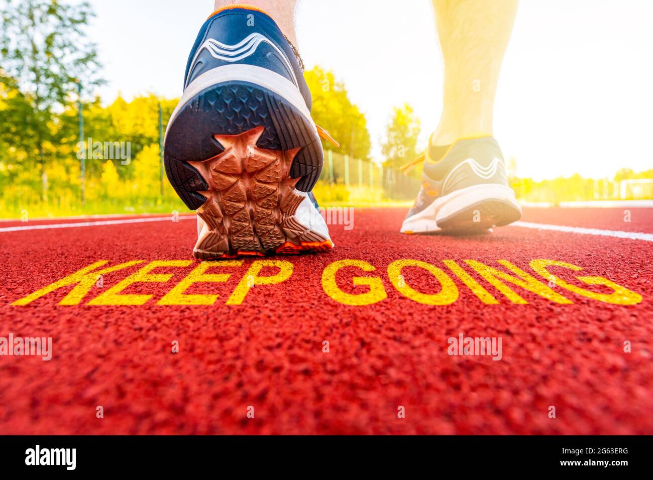 Athlete runner feet and message KEEP GOING on a on a running track