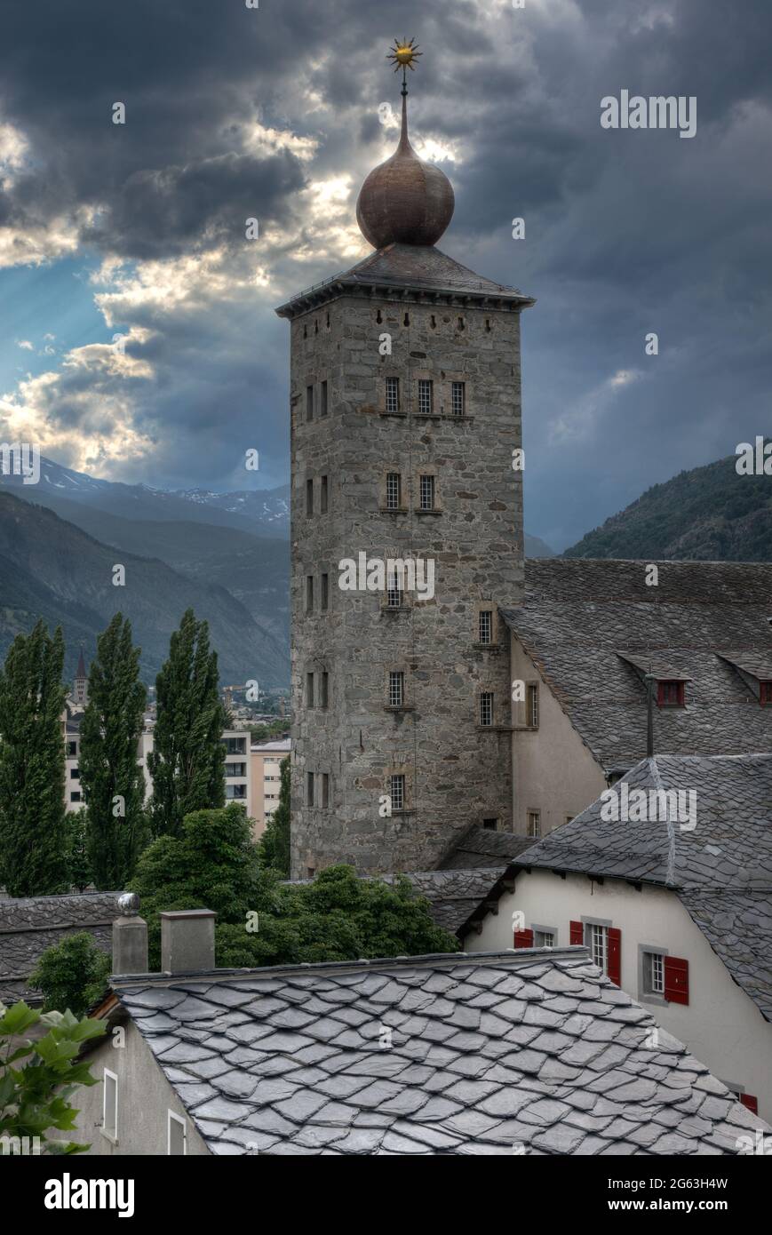 Tower of the Stockalper Palace in Brig, Switzerland, in the background mountains and dark, threatening clouds Stock Photo