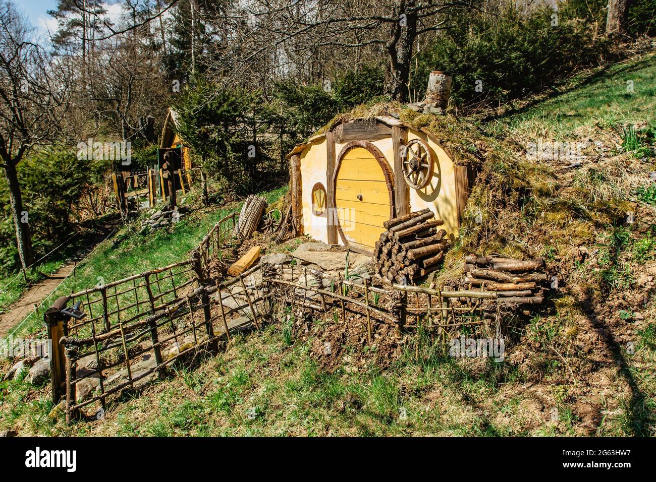 Hobbit house in Czech Hobbiton with three Hobbit holes and cute yellow doors.Fairy tale home in garden.Magic small village from fantasy movie located Stock Photo