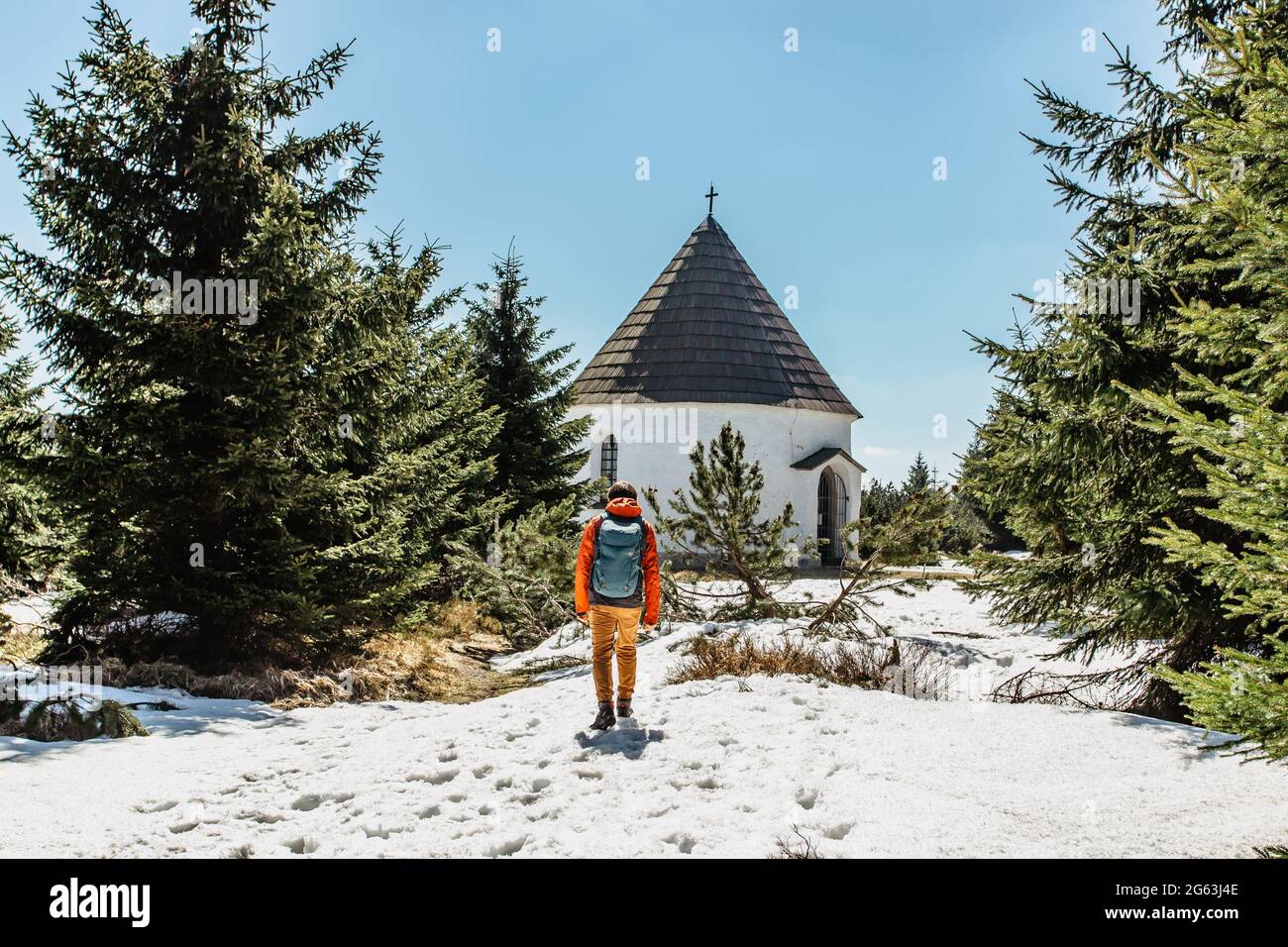 Backpacker at baroque Chapel of the Visitation of the Virgin Mary,Kunstat Chapel, located in Eagle Mountains at altitude of 1035 m, Czech Republic. Stock Photo