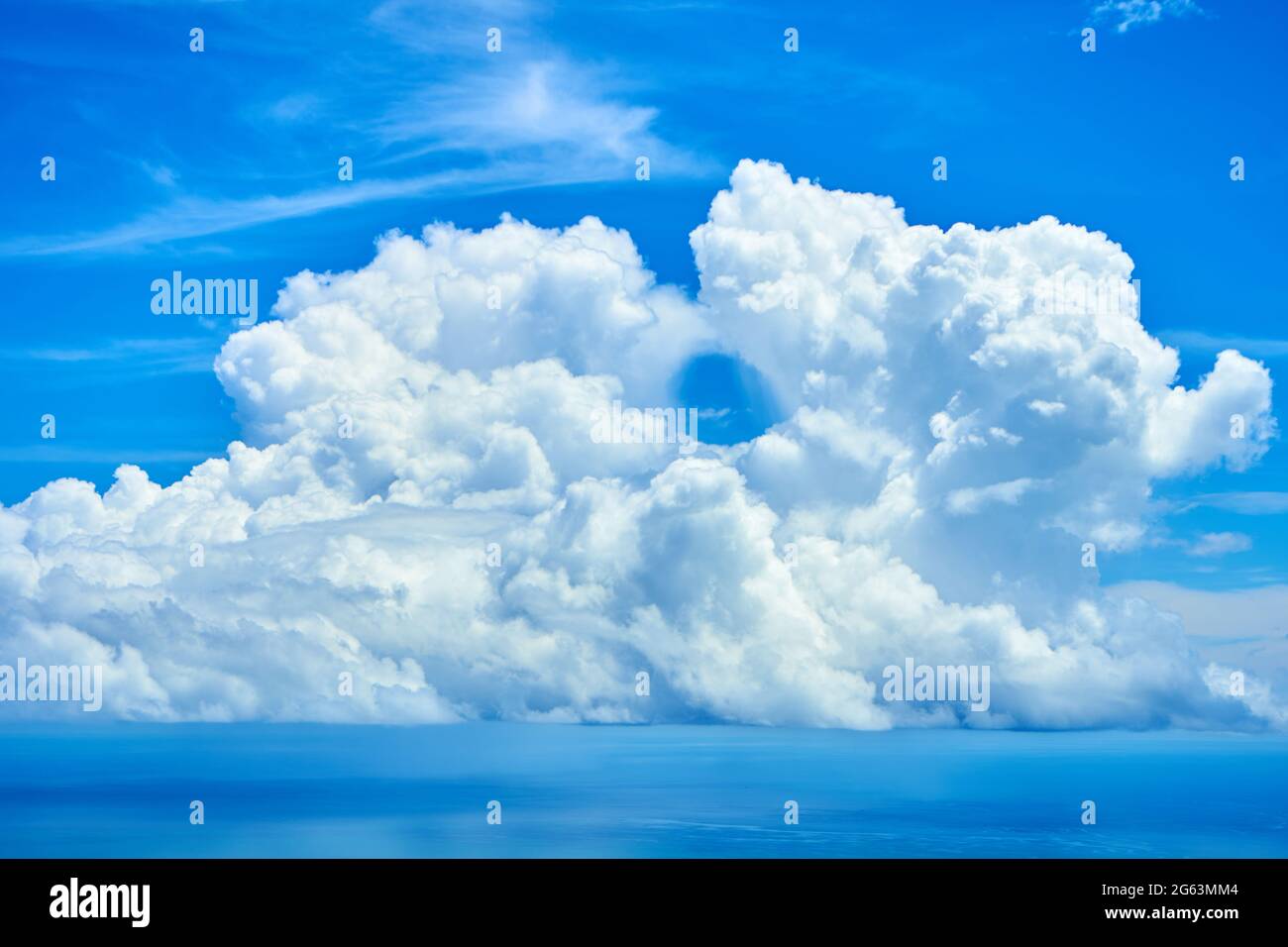 Fluffy white clouds over blue ocean water Stock Photo - Alamy