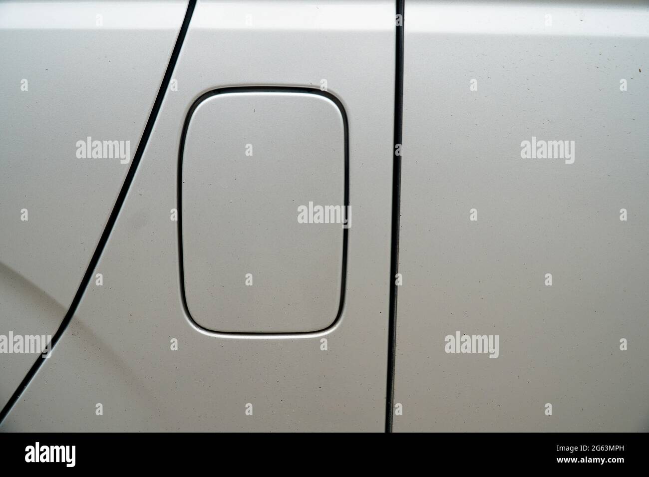 A close up of a petrol cap cover on a modern white car, car's fuel tank