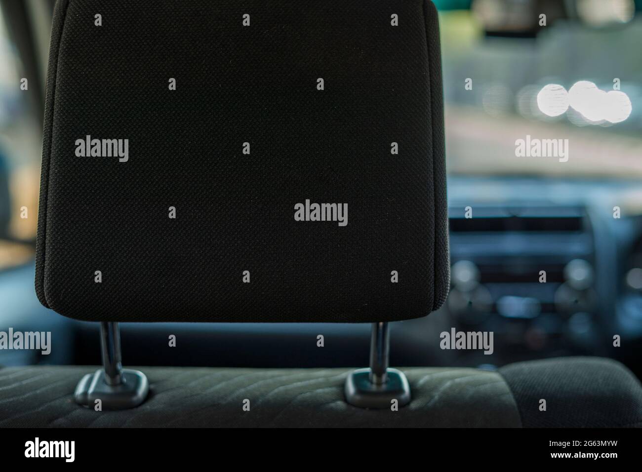 Hand adjusts headrest in car interior. adjusting the seat position in