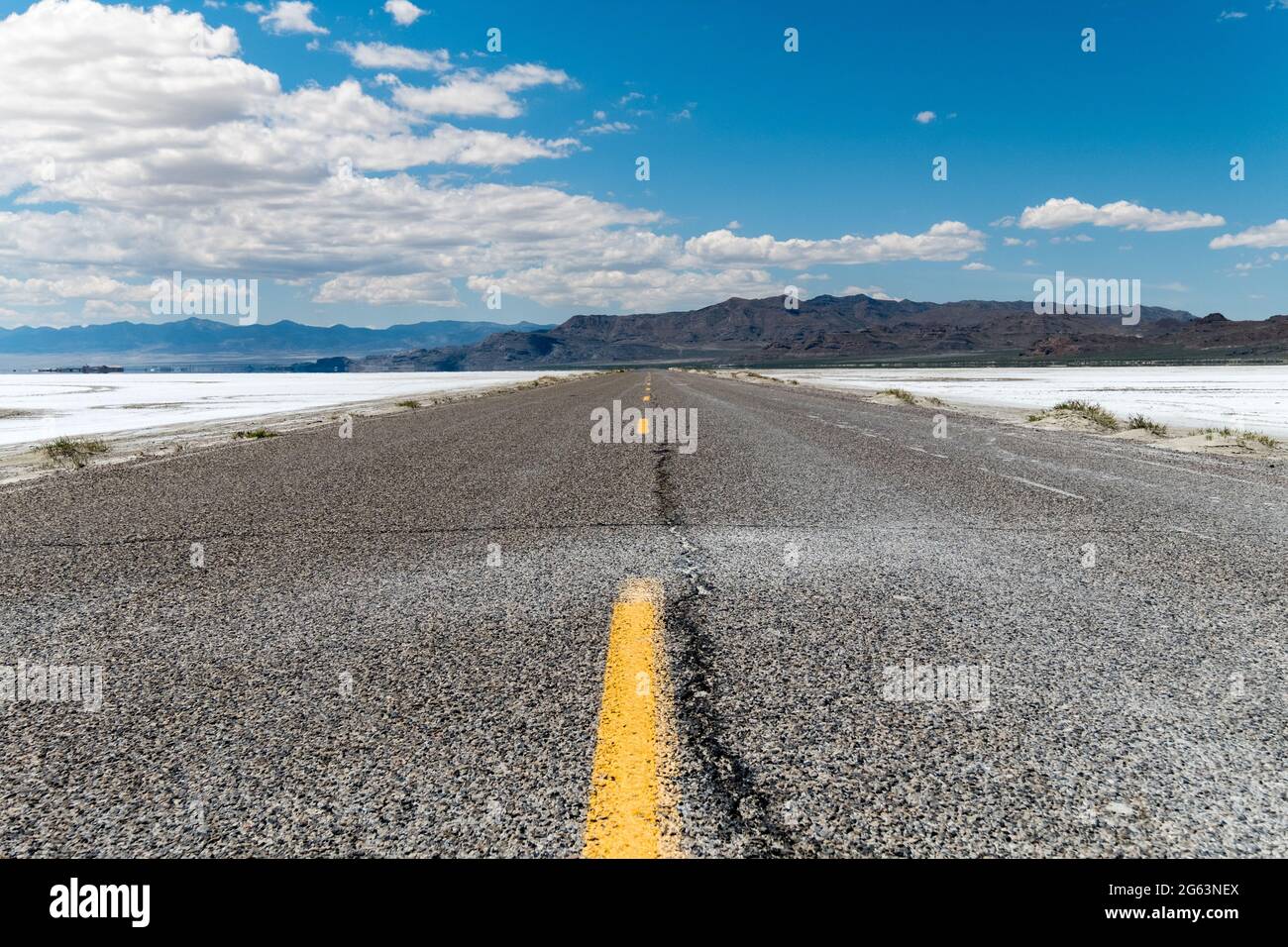 Lower angle of an empty road with some mountains on the horizon