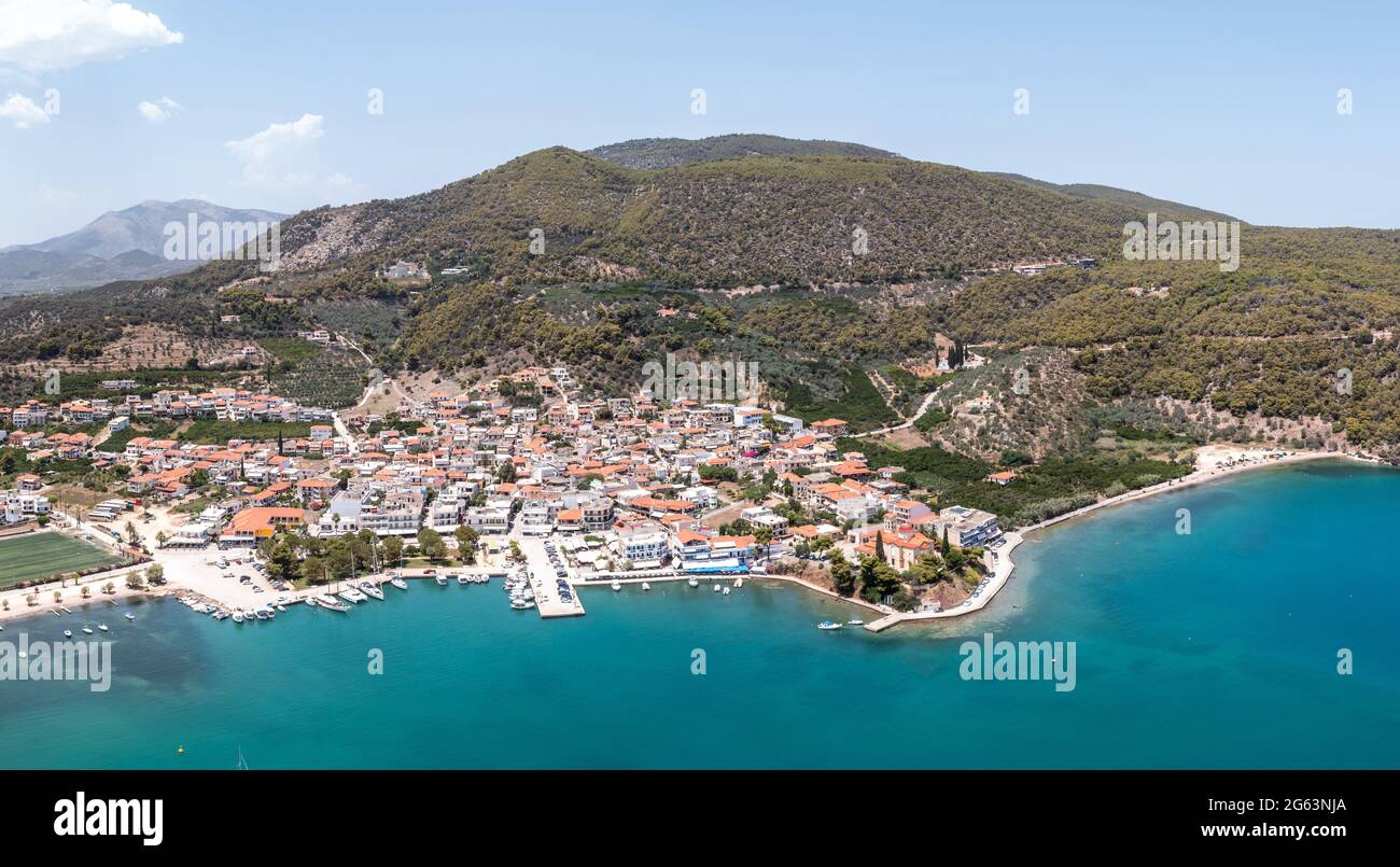 Greece, Ancient Epidaurus town beach and port at Peloponnese, aerial, drone view. Traditional village, boats and vessels moored at port, Argolida natu Stock Photo