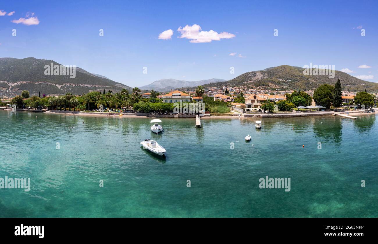 Greece, Ancient Epidaurus town and beach at Argolida, aerial drone view. Traditional village, boats and vessels moored at marina Peloponnese nature ba Stock Photo