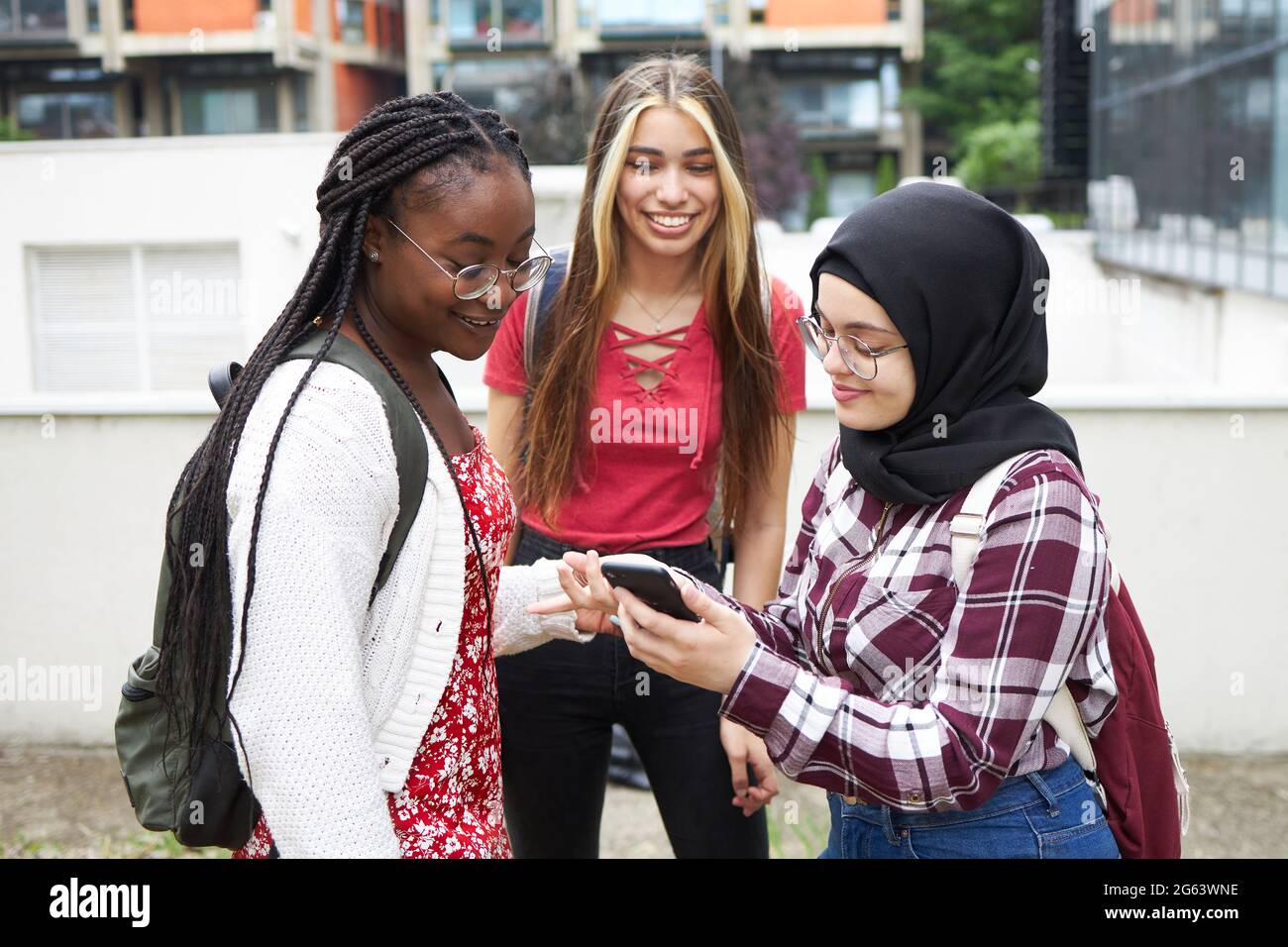 A girl showing a phone to her friends Stock Photo