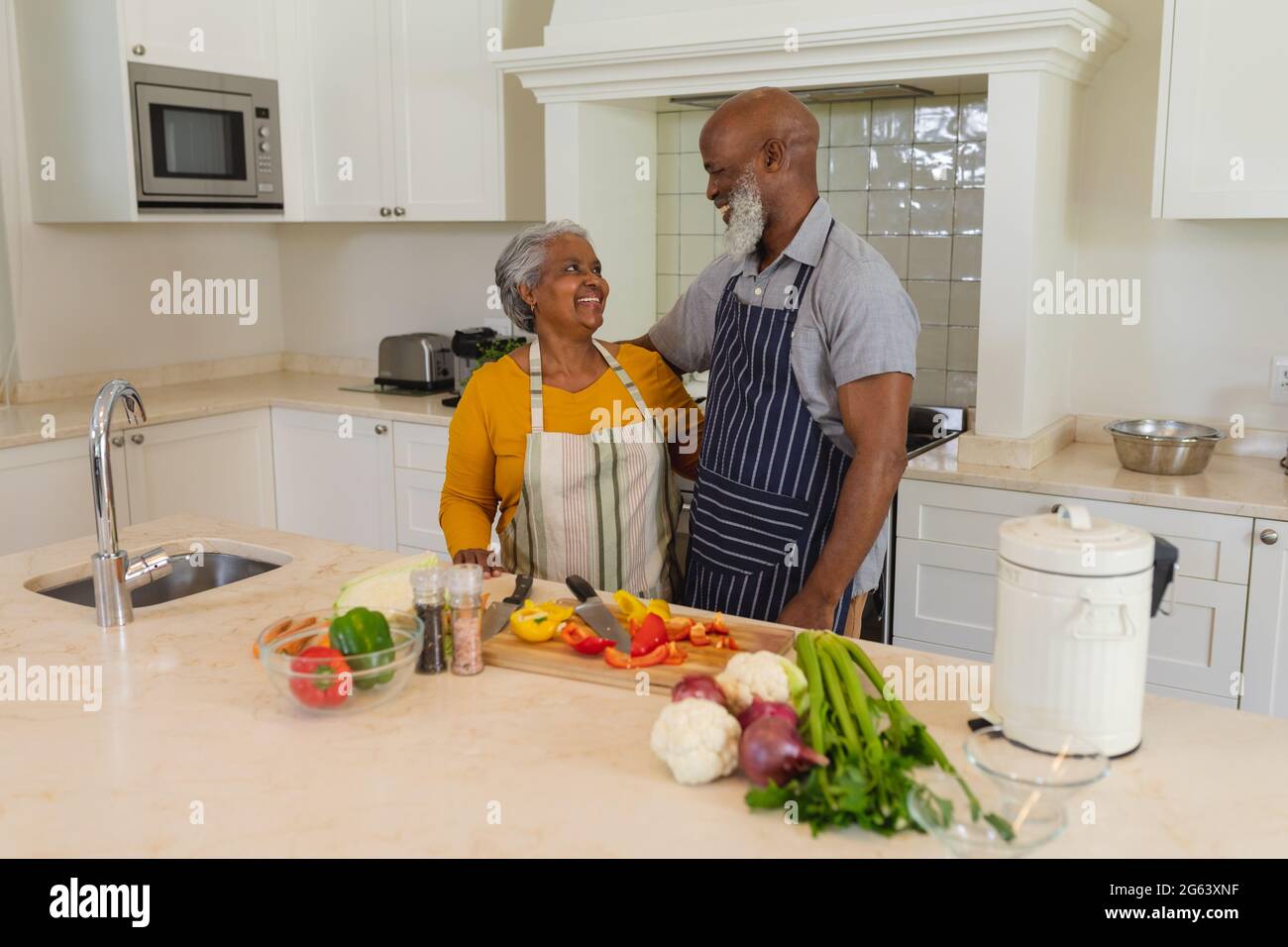 Senior african american couple cooking together in kitchen smiling ...