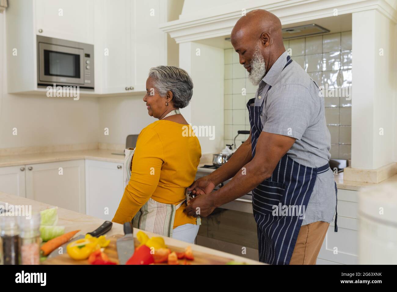 Senior african american couple cooking together in kitchen smiling ...
