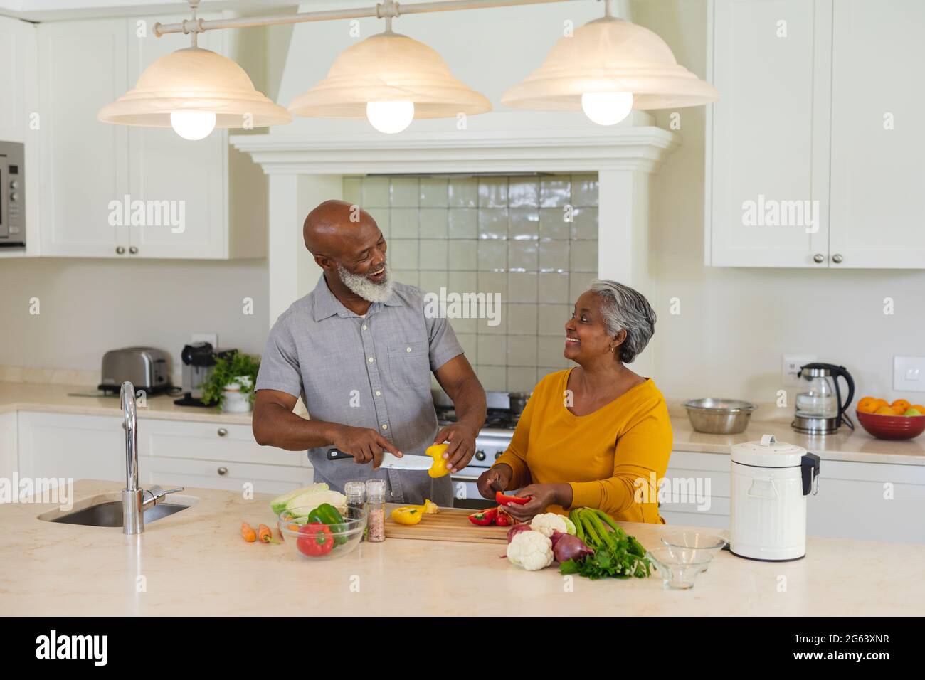 Senior african american couple cooking together in kitchen smiling ...