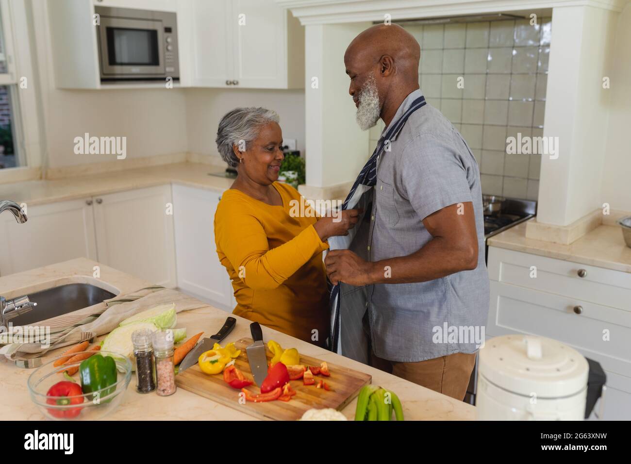 Senior african american couple cooking together in kitchen smiling ...