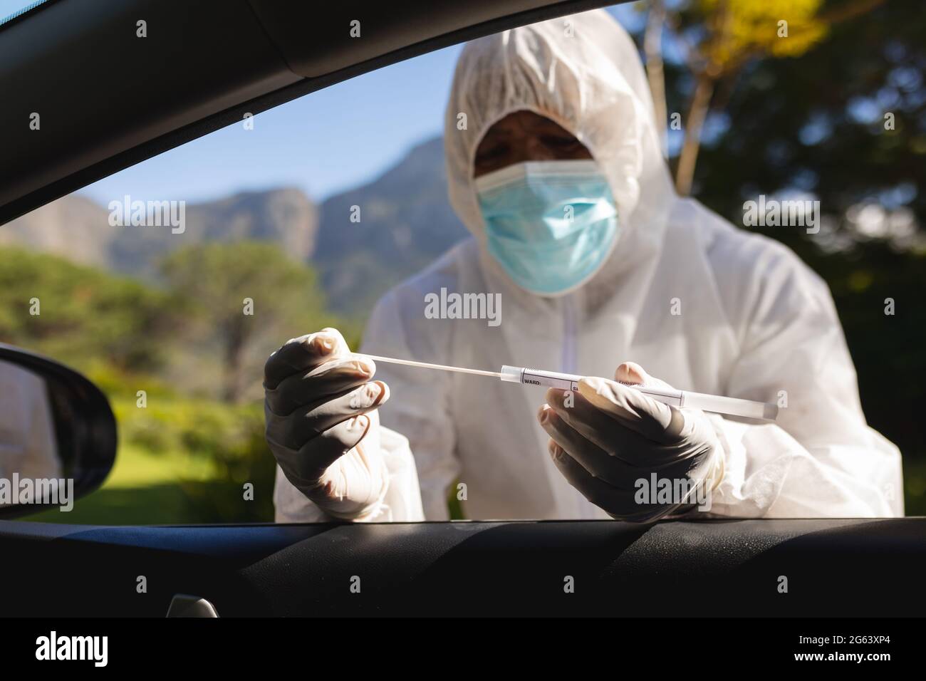 Medical worker wearing ppe suit taking swab test Stock Photo