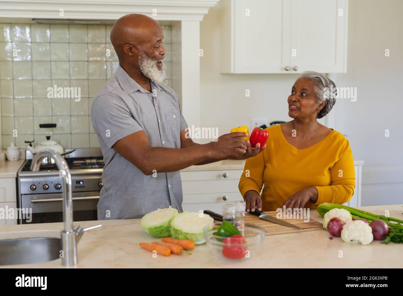 Senior african american couple cooking together in kitchen smiling ...