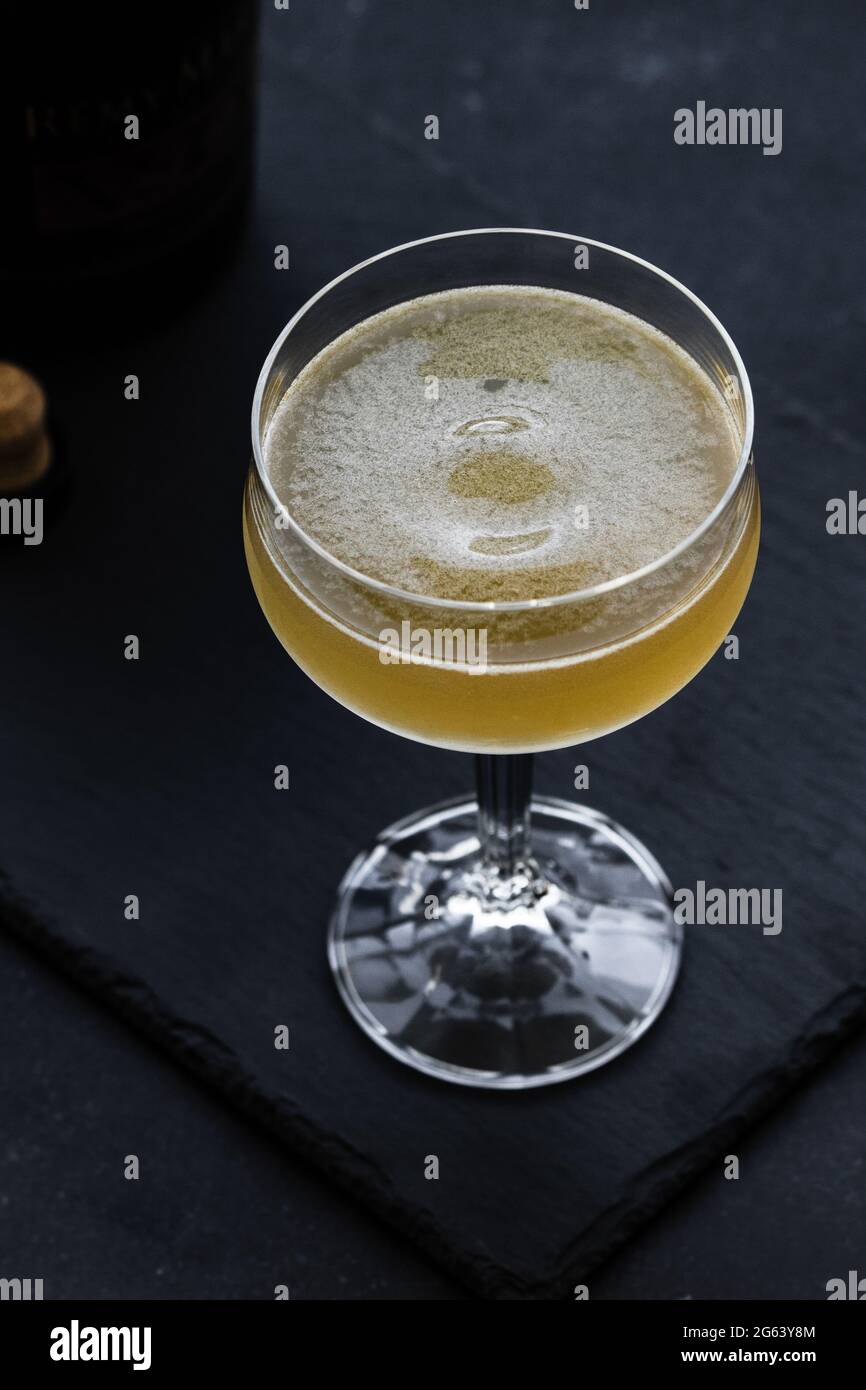 Yellow cocktail (Between the sheets) on dark background. Elegant cocktail with cognac. Stock Photo