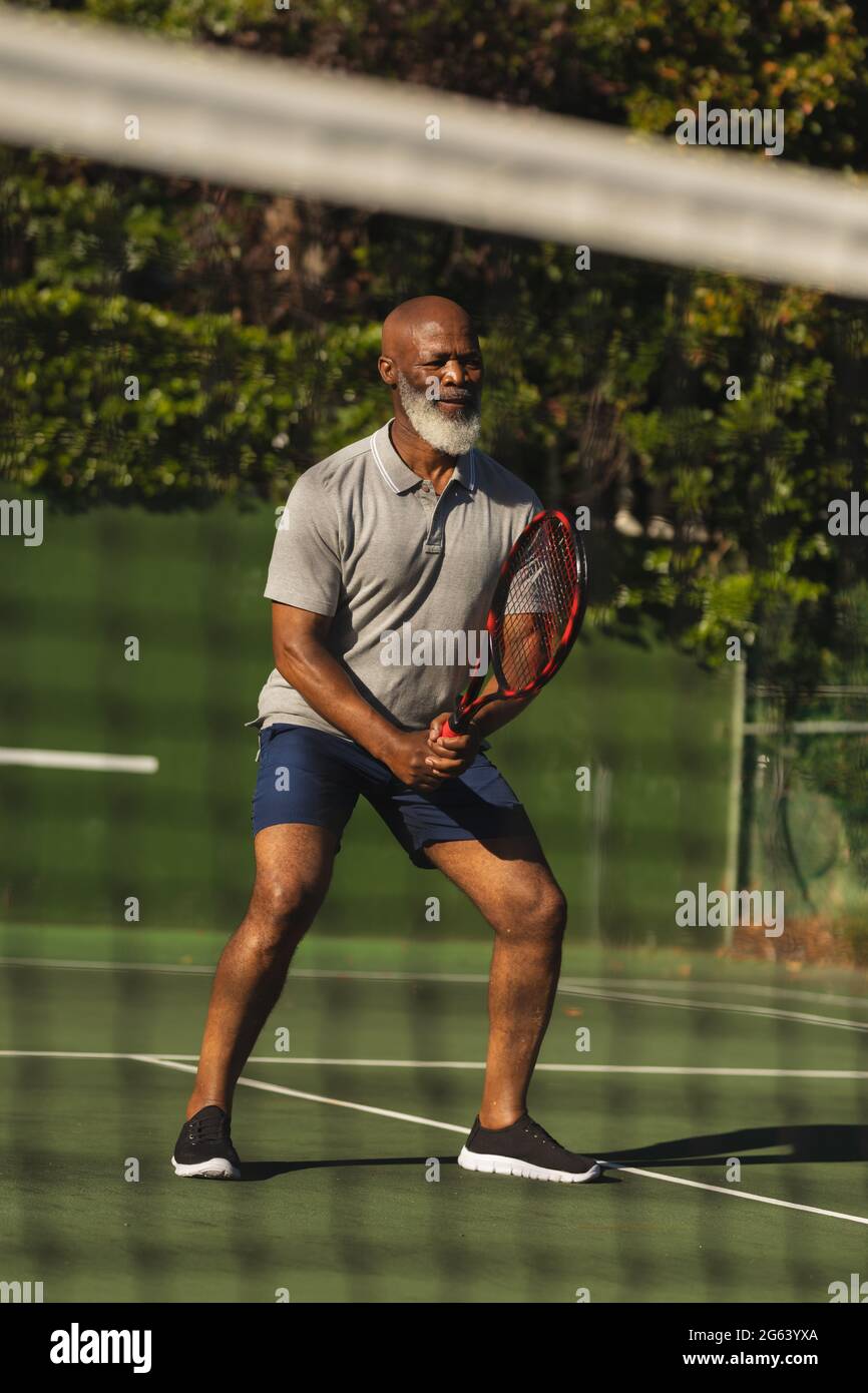 Senior african american man playing tennis on tennis court Stock Photo