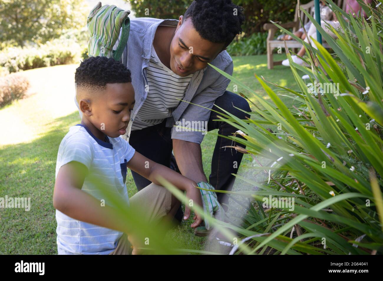 Happy african american father with son outdoors, gardening on sunny day Stock Photo